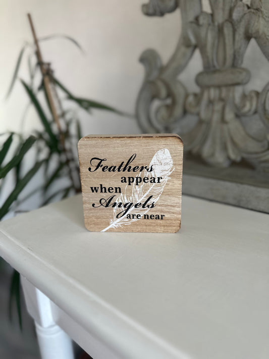 Feathers appear when angels are near wooden plaque sign